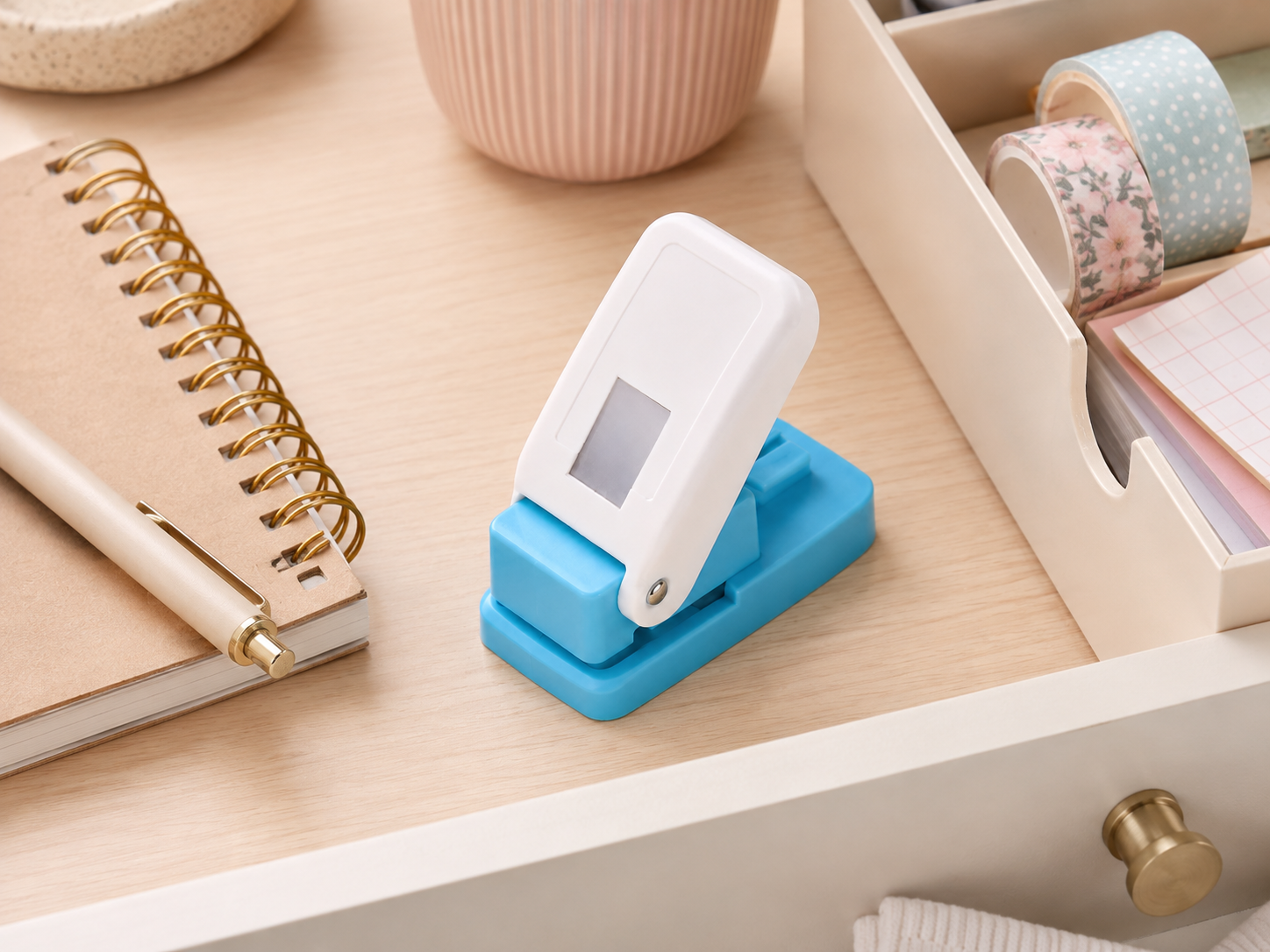 Paper punch shown next to everyday desk objects for scale