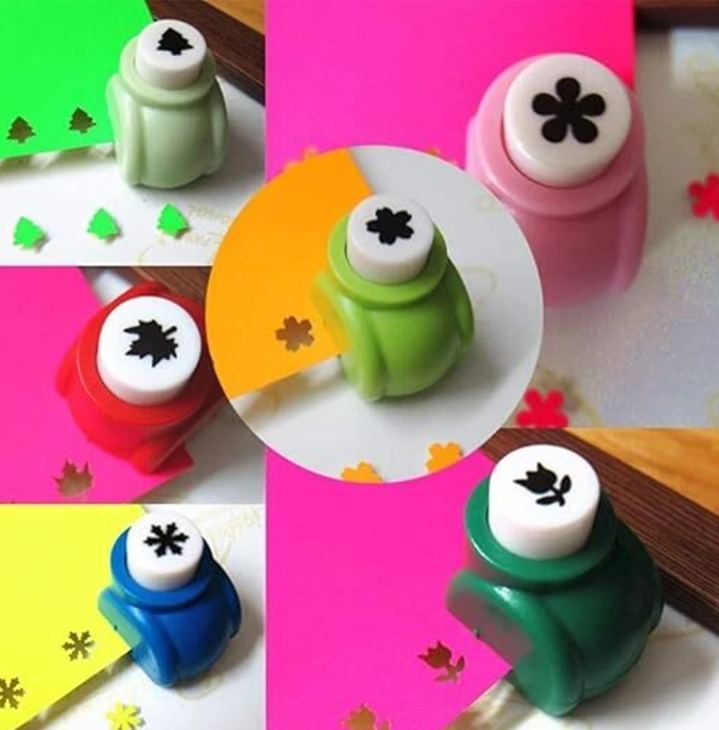Hand holding a paper punch over craft paper